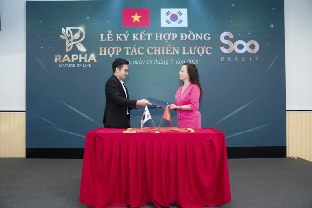 Lễ ký kết hợp đồng hợp tác chiến lược, phông nền có logo Rapha và Soo Beauty cùng cờ Việt Nam và Hàn Quốc